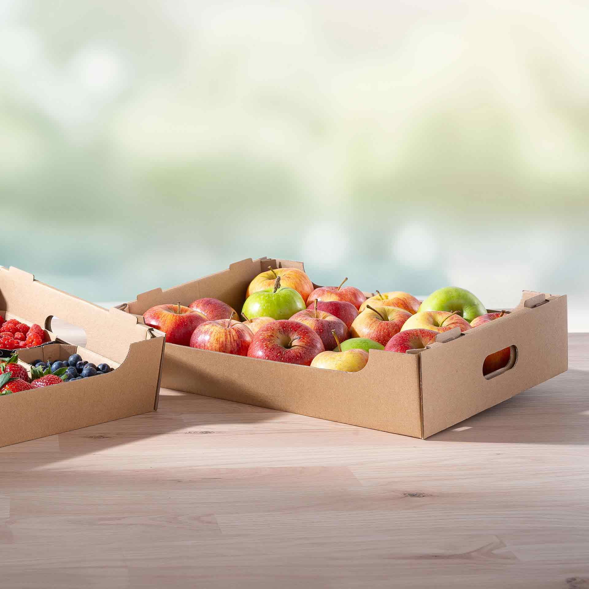 Zwei Steigen gefüllt mit Äpfel und Beeren