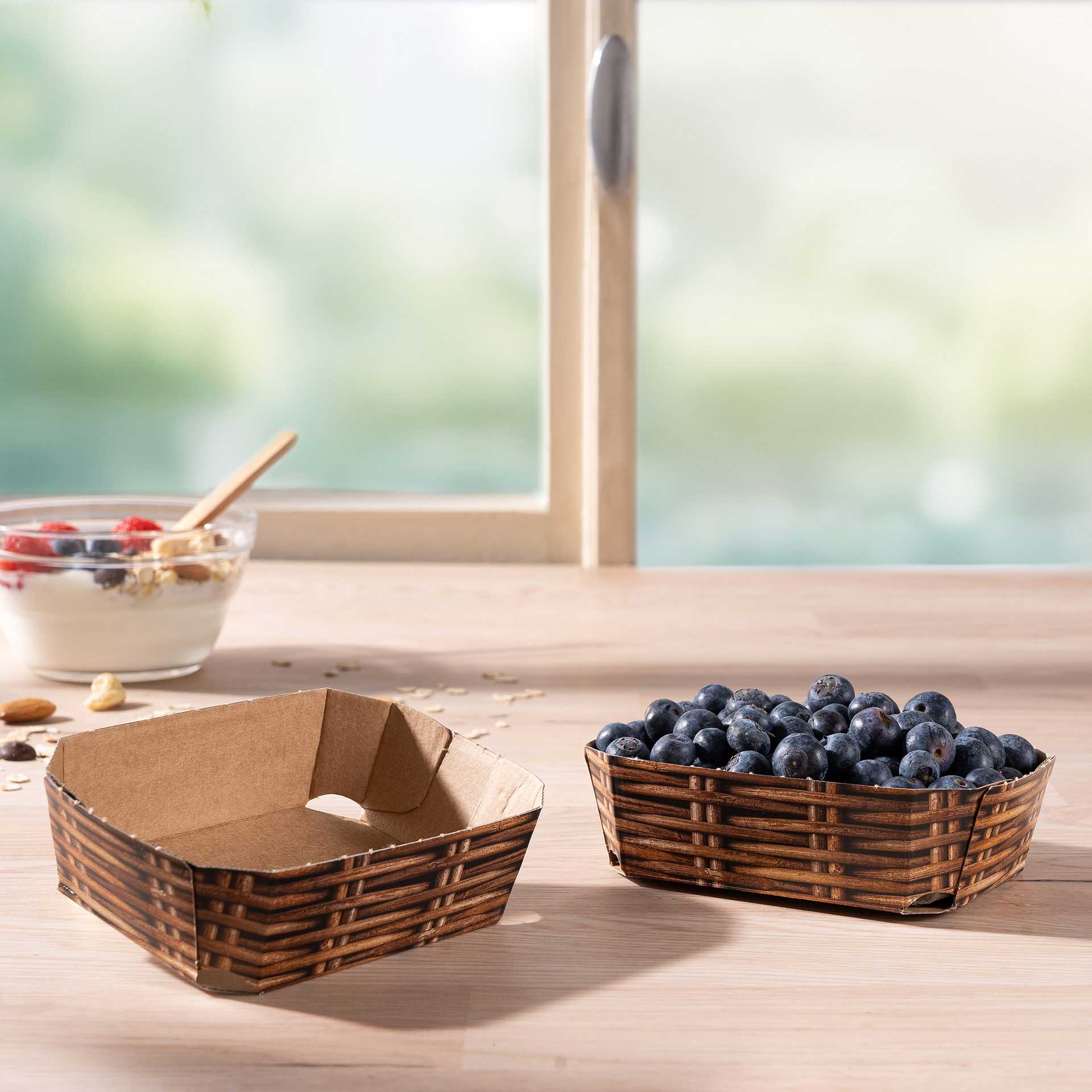 Zwei Beerenschalen aus Wellpappe 125g mit Blaubeeren auf einem Tisch
