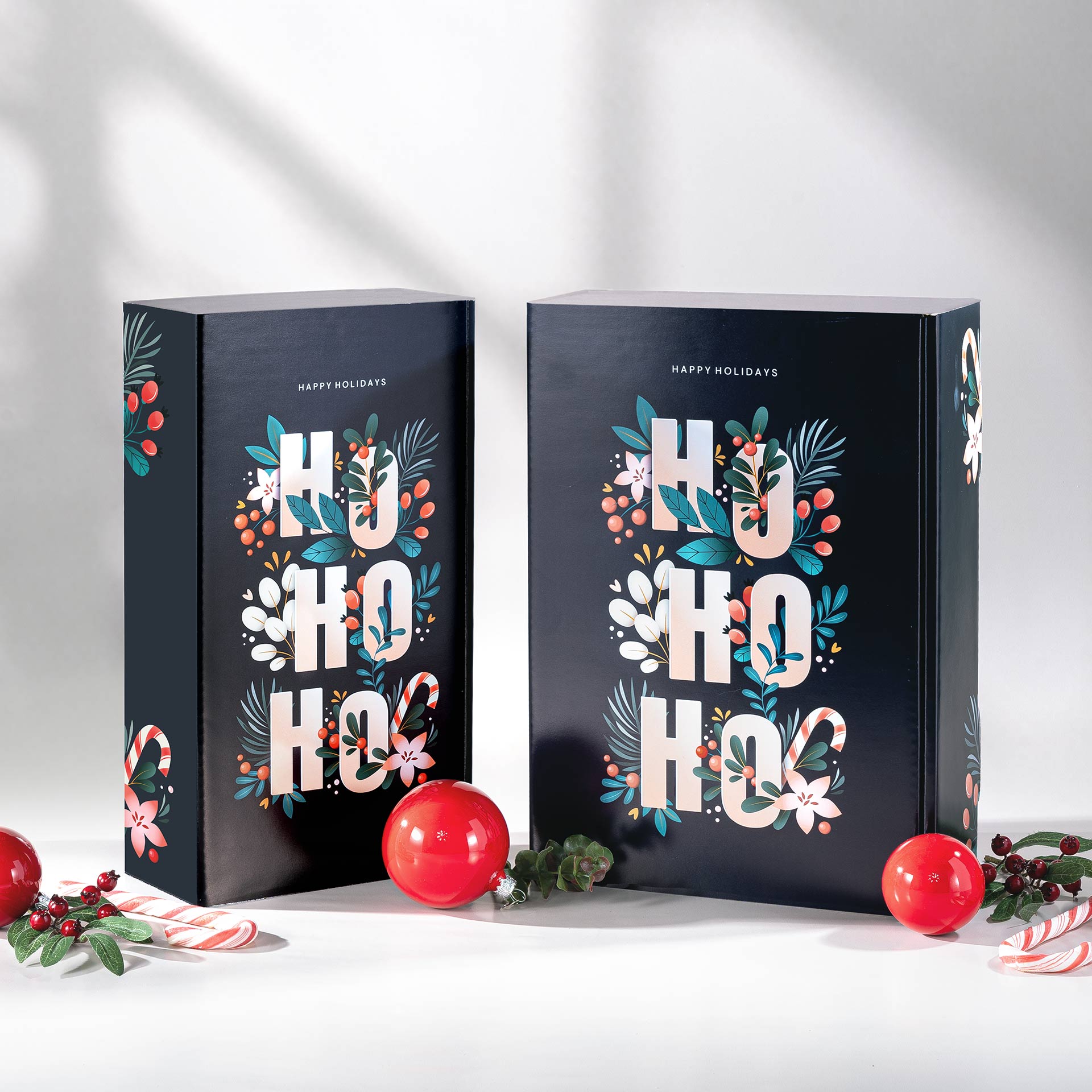Präsentkarton - Hohoho - 2 x 0,75 l Zwei Geschenkverpackungen mit dem Design Hohoho im Vordergrund mit weihnachtlichen Elementen
