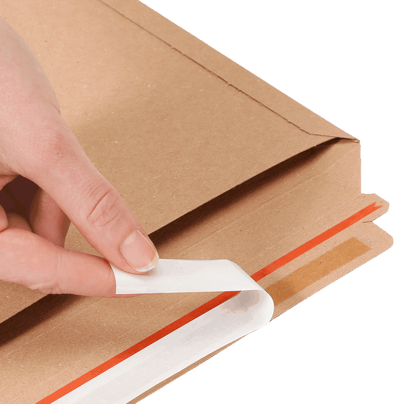 Eine Hand zieht den Selbstklebestreifen einer Versandtasche aus Vollpappe S ab