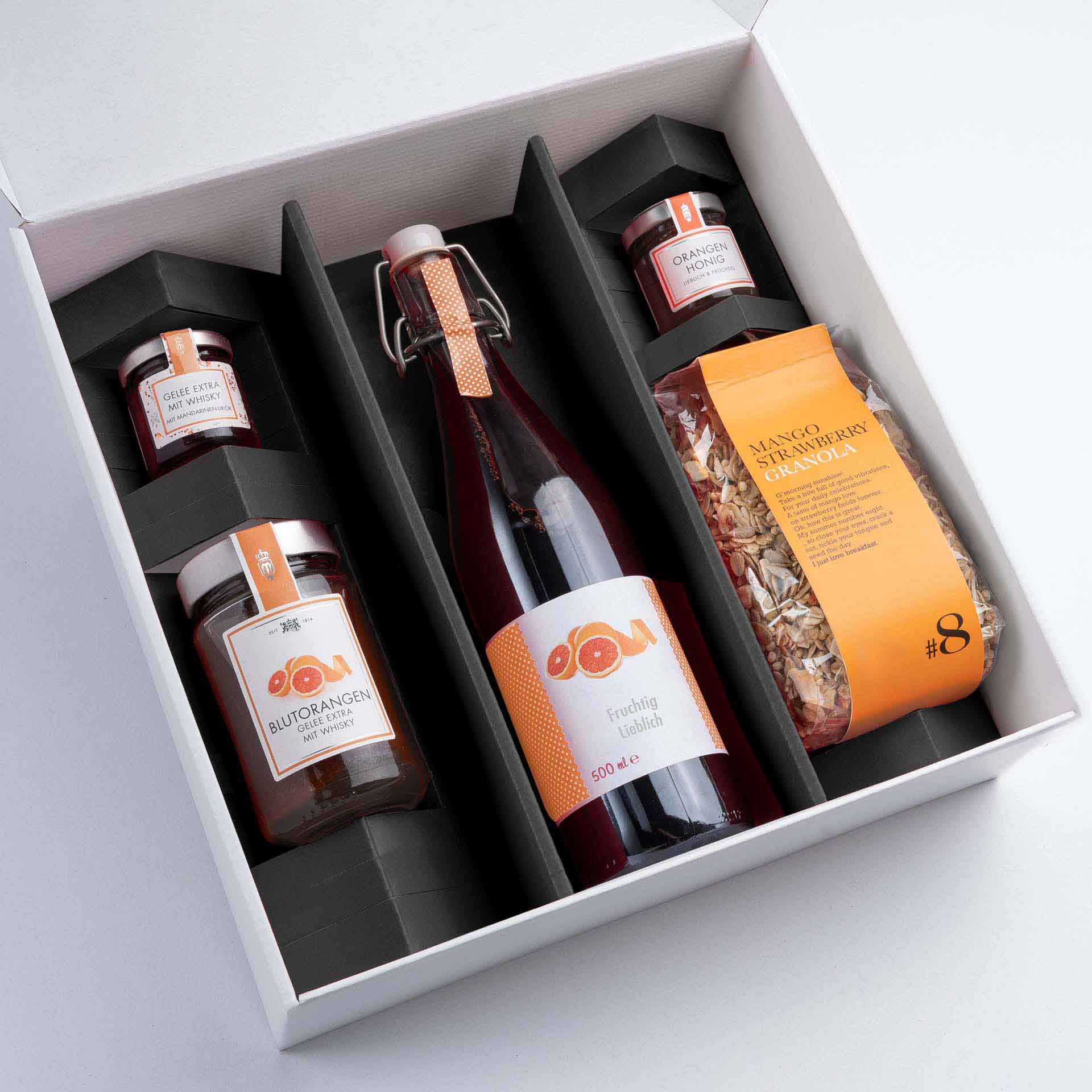 Schwarze Einlage in einer weißen Geschenkbox groß und Produkten