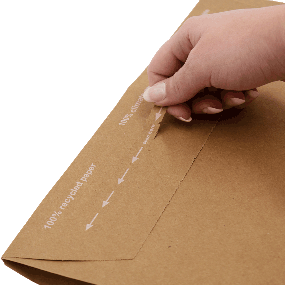 Eine Hand öffnet die Versandtasche aus Papier an einem Aufreißfaden