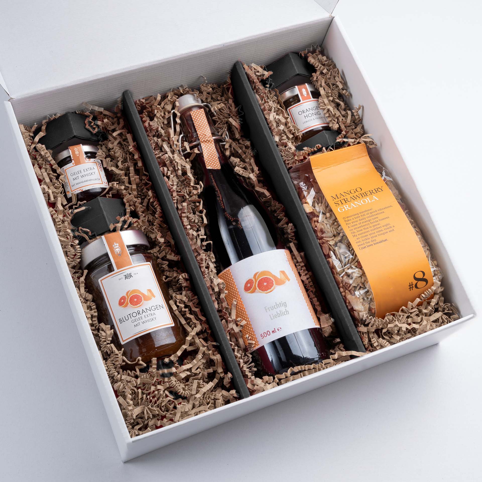 Schwarze Einlage in einer weißen Geschenkbox groß mit SizzlePak und Produkten